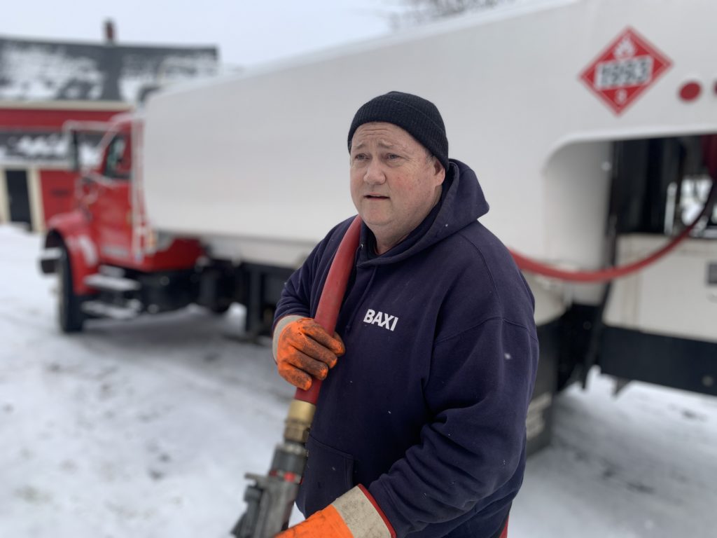 AJ pulling the oil hose to the customer's fill pipe as he prepares to fill their tank with home heating oil.